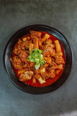 Kore yemeği Baharatlı Karıştırılmış Kızarmış Tavuk tteokbokki siyah tabakta