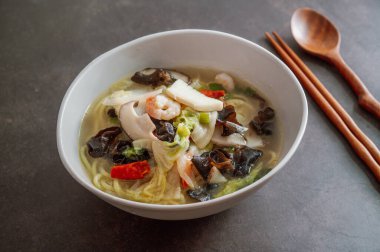 Kore usulü baharatlı beyaz şehriye çorbası ve deniz ürünleri jjamppong 'u.