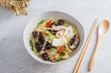 Kore usulü baharatlı beyaz şehriye çorbası ve deniz ürünleri jjamppong 'u.