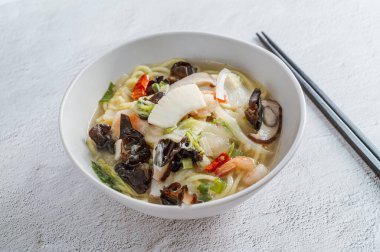 Kore usulü baharatlı beyaz şehriye çorbası ve deniz ürünleri jjamppong 'u.