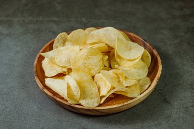 Tahta tabakta servis edilen patates cipsi.