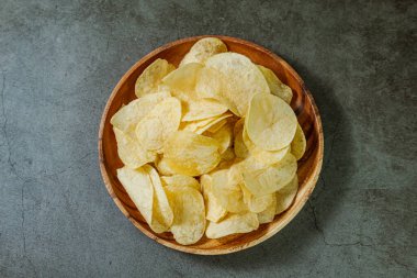 Tahta tabakta servis edilen patates cipsi.