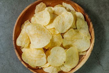 Tahta tabakta servis edilen patates cipsi.