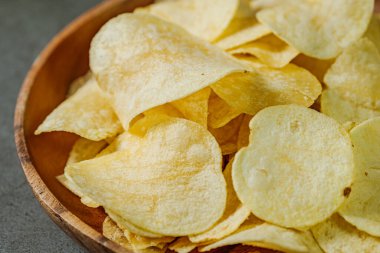 Tahta tabakta servis edilen patates cipsi.