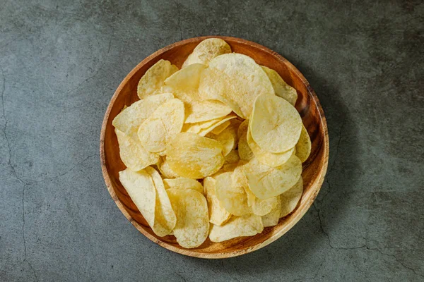 Tahta tabakta servis edilen patates cipsi.