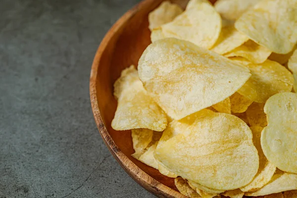 Tahta tabakta servis edilen patates cipsi.