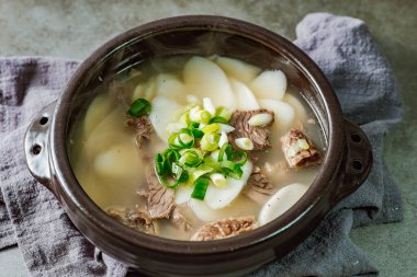 Tteokguk, Kore Dilimlenmiş Pirinç Keki Çorbası: Oval şekilli pirinç keki çorbası çorbada pişirildi. Geleneksel bir Ay Yeni Yılı yemeği. Net et et suyu genellikle kullanılır, ancak tavuk veya deniz ürünleri eklenebilir..