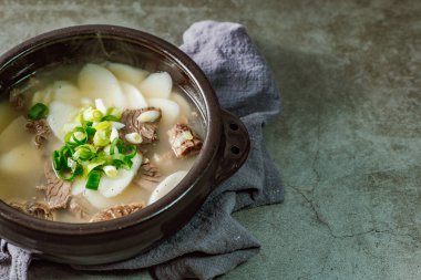 Tteokguk, Kore Dilimlenmiş Pirinç Keki Çorbası: Oval şekilli pirinç keki çorbası çorbada pişirildi. Geleneksel bir Ay Yeni Yılı yemeği. Net et et suyu genellikle kullanılır, ancak tavuk veya deniz ürünleri eklenebilir..