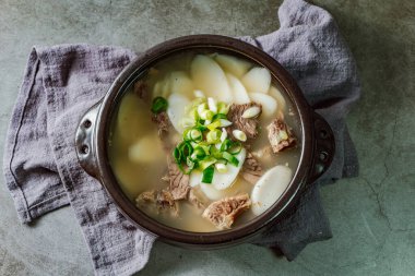 Tteokguk, Kore Dilimlenmiş Pirinç Keki Çorbası: Oval şekilli pirinç keki çorbası çorbada pişirildi. Geleneksel bir Ay Yeni Yılı yemeği. Net et et suyu genellikle kullanılır, ancak tavuk veya deniz ürünleri eklenebilir..