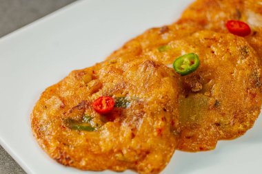 Kimchijeon, Kore yemeği kimchi krepi, un hamuru ve közde kızartılmış kimchi dilimleri. İnce doğranmış domuz eti, kalamar ve istiridye eti de hamura eklenebilir..