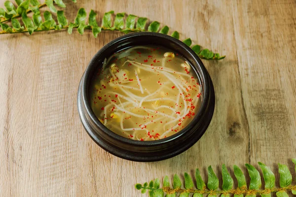 コンナムグク 韓国の豆の芽スープ この明確なスープは 水で煮込んだ豆の芽で作られています 塩だけで味付けされたコンナムグクは 寒さやたまり場の緩和に効果があることが知られています 赤唐辛子の粉を追加します — ストック写真