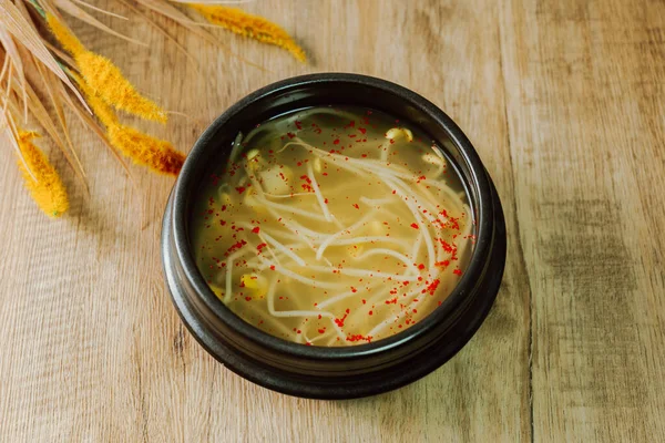 コンナムグク 韓国の豆の芽スープ この明確なスープは 水で煮込んだ豆の芽で作られています 塩だけで味付けされたコンナムグクは 寒さやたまり場の緩和に効果があることが知られています 赤唐辛子の粉を追加します — ストック写真
