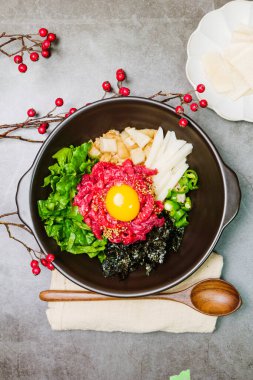 Yukhoebimbap, Kore usulü Tartare Bibimbap: Mevsimlik namul (baharatlı sebze) ve taze yukhoe (doğranmış çiğ sığır eti) ile kaplanmış ve baharatla servis edilen bir kase pirinç. Taze kalça ya da yuvarlak göz tercih edilir. 