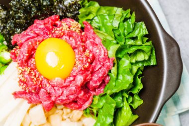 Yukhoebimbap, Kore usulü Tartare Bibimbap: Mevsimlik namul (baharatlı sebze) ve taze yukhoe (doğranmış çiğ sığır eti) ile kaplanmış ve baharatla servis edilen bir kase pirinç. Taze kalça ya da yuvarlak göz tercih edilir. 