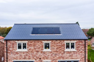 SKIPWith, İngiltere - 20 Ekim 2021. Çatıda fotovoltaik güneş panellerinden inşa edilen ve iç kullanım için temiz ve yenilenebilir enerji üreten yeni bir ev