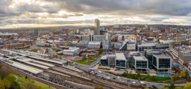 SHEFFIELD, İngiltere - 4 Kasım 2021. Gün batımında Sheffield şehir merkezinin tren istasyonu ve Elektrik İşleri 'nin hava manzarası.