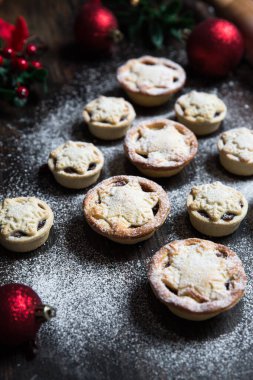 A home baking concept of traditional Christmas mince pies arranged in the shape of a Christmas Tree and covered in icing sugar