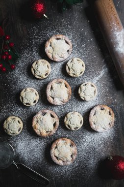 A home baking concept of traditional Christmas mince pies arranged in the shape of a Christmas Tree and covered in icing sugar