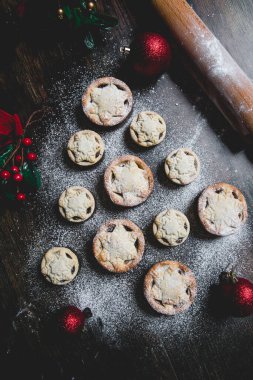 A home baking concept of traditional Christmas mince pies arranged in the shape of a Christmas Tree and covered in icing sugar