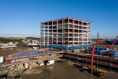 İnşaat alanının üzerine inşa edilmiş ve etrafı kopya alanlarla çevrili bir bina.