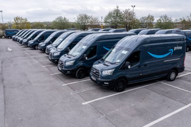Leeds, İngiltere - 25 Nisan 2022. Amazon Prime Ford Transit nakliye araçlarının bir filosu İngiltere 'deki evlere çevrimiçi alışveriş malzemeleri götürmek için yüklenmeye hazır.