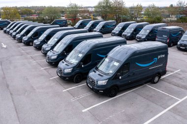 Leeds, İngiltere - 25 Nisan 2022. Amazon Prime Ford Transit nakliye araçlarının bir filosu İngiltere 'deki evlere çevrimiçi alışveriş malzemeleri götürmek için yüklenmeye hazır.
