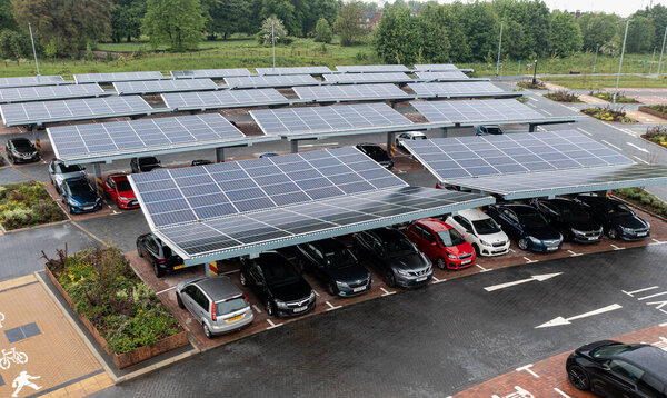 STOURTON, LEEDS, UK - MAY 16, 2022.  Aerial view above innovative solar panels located on a car parking lot rooftops making good use of small space in a city