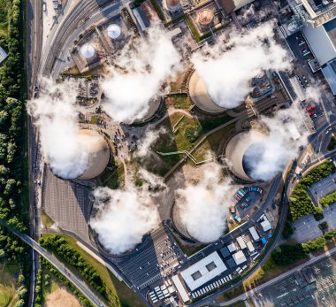 Büyük bir kömür santraline buhar yayan bir grup soğutma kulelerinin yukarıdan aşağı görüntüsü
