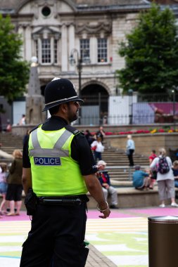 BIRMINGHAM, UK - JULY 28, 2022.  A rear view of an Asian policeman in uniform on the street of a UK city showing diversity in the police force