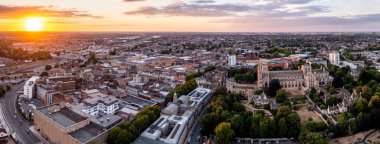 PETERBOROUGH, UK - AUGUST 4, 2022.  An aerial panorama cityscape of Peterborough Cathedral and town centre at sunset