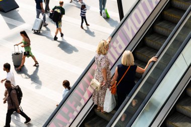 BIRMINGHAM, UK - AUGUST 9, 2022. The interior foyer and concourse of Birmingham New Street Railway Station with commuters, passengers and shoppers using escalators