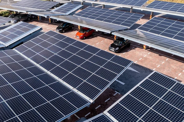 LEEDS, UK - AUGUST 19, 2022.  Aerial view above innovative solar panels located on a car parking lot rooftops making good use of small space in a city to provode sustainable energy for electric vehicle charging