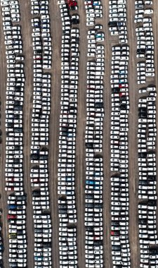An aerial view of rows of newly built cars and vehicles ready for export and import and delivery to sales dealerships