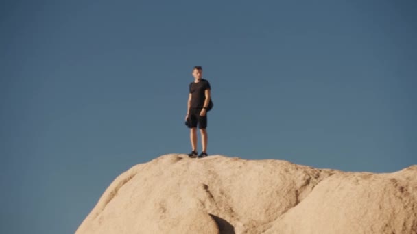 Hombre fotógrafo en la parte superior de la roca — Vídeo de stock