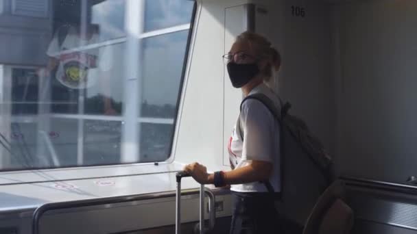 Жінка в масці подорожі поїздом — стокове відео