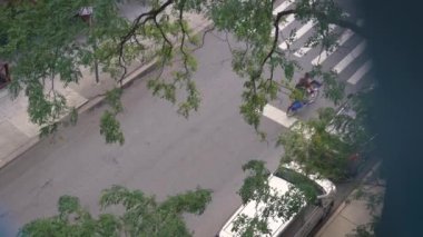 Şehrin üst manzarasında arabalar ve elektrikli bisiklet sürüyor.