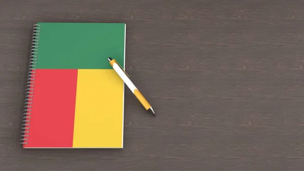 İçinde Benin bayrağı ve yalancı bir kalem olan bir defter.