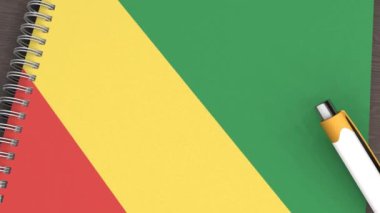 Üzerinde Kongo Cumhuriyeti bayrağı ve yalancı bir kalem olan bir defter.