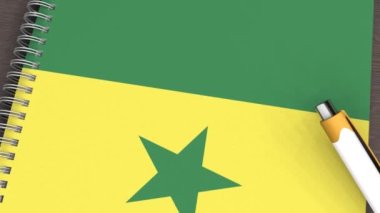 Senegal bayrağı ve yalan kalemi olan bir defter.