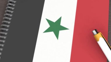 Suriye bayrağı ve yalancı bir kalemin olduğu bir defter.