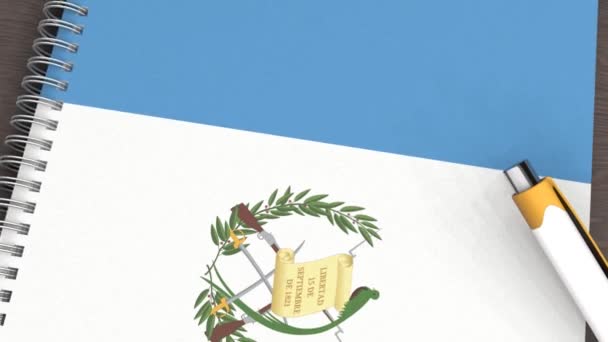 Ένα Σημειωματάριο Σημαία Της Γουατεμάλας Και Ένα Στυλό Που Βρίσκεται — Αρχείο Βίντεο