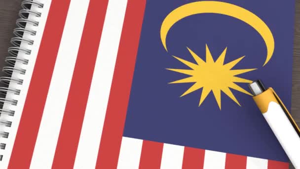 Ένα Σημειωματάριο Σημαία Της Μαλαισίας Και Ένα Στυλό Που Βρίσκεται — Αρχείο Βίντεο