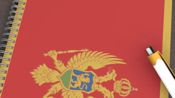 Ένα Σημειωματάριο Σημαία Του Μαυροβουνίου Και Ένα Στυλό — Αρχείο Βίντεο