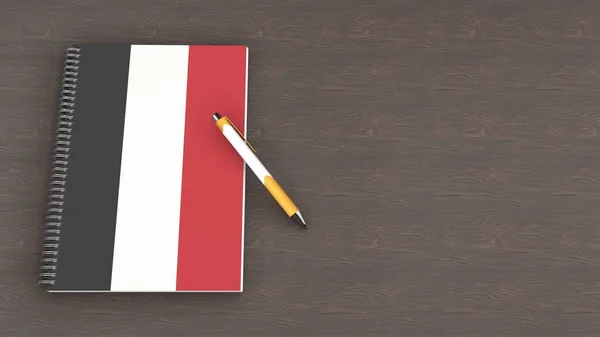 İçinde Yemen bayrağı ve yalancı bir kalem olan bir defter.
