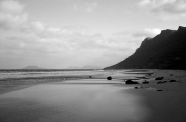 Arka planda uçurumları olan vahşi sahil Caleta de Famara, Lanzarote, Kanarya Adaları, İspanya