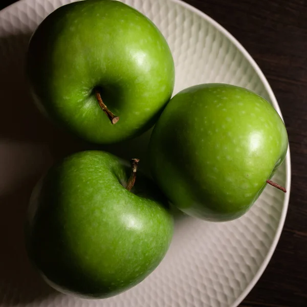 Drie Sappige Groene Appels Liggen Een Witte Plaat Een Donkere — Stockfoto