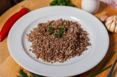 Bir porsiyon karabuğday kaynamış bir meze içinde ahşap bir arka planda beyaz bir tabakta