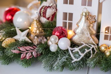 Beyaz evler, köknar dalları, koniler ve bir kaz heykelciği ile yeni yıl kompozisyonu