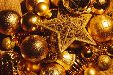 Parlak altın Noel ağacı oyuncakları. Farklı şekillerde bir yıldız ve toplar..