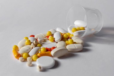 Beyaz zemin üzerinde tablet, kapsül, vitamin, sarı, kırmızı, turuncu ve beyaz fotoğraflar